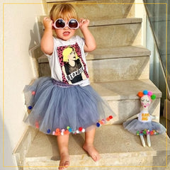 girls wearing a grey tulle tutu with multicoloured pompoms